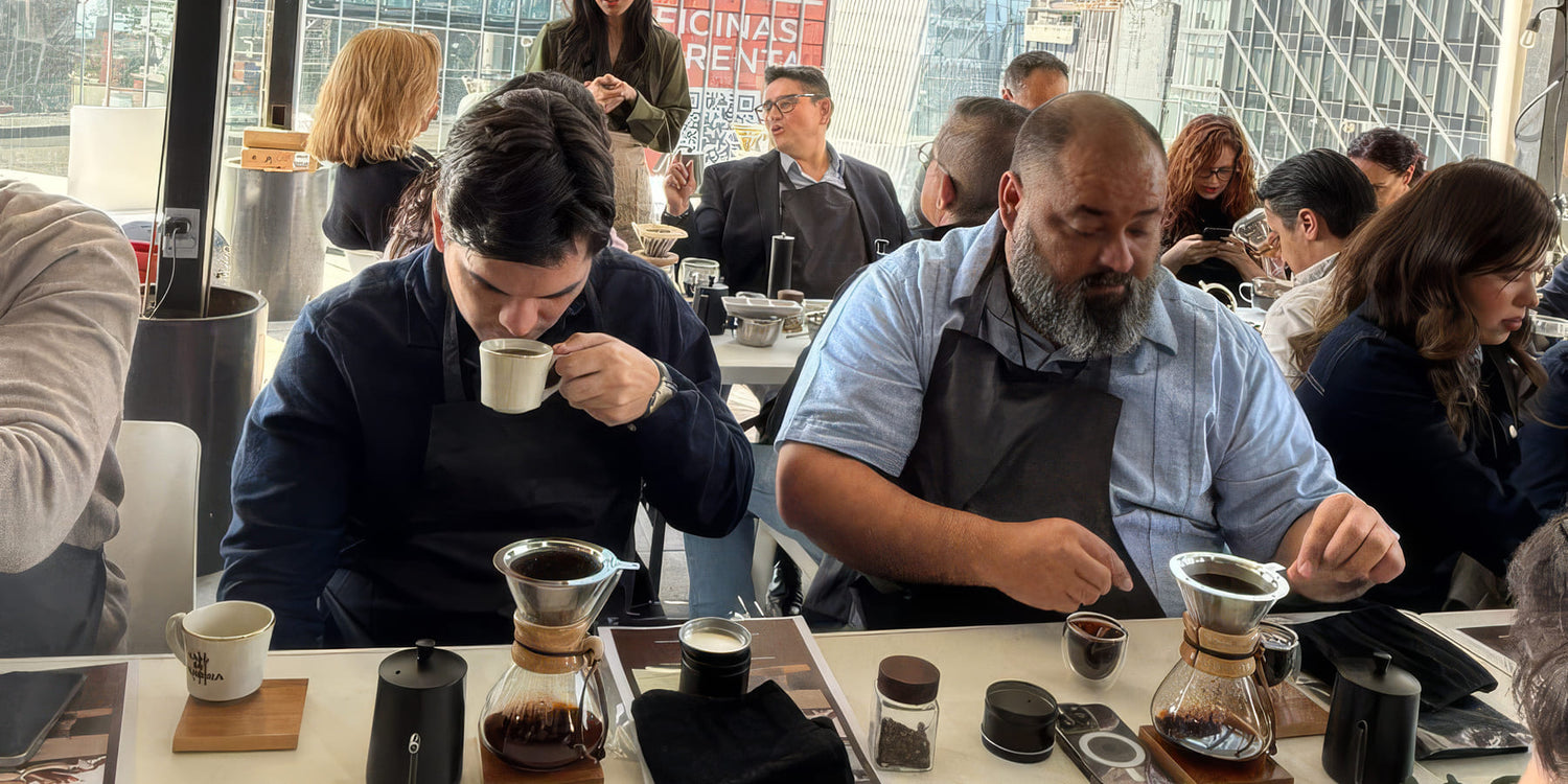 Dos asistentes probando café recién preparado durante una cata al aire libre